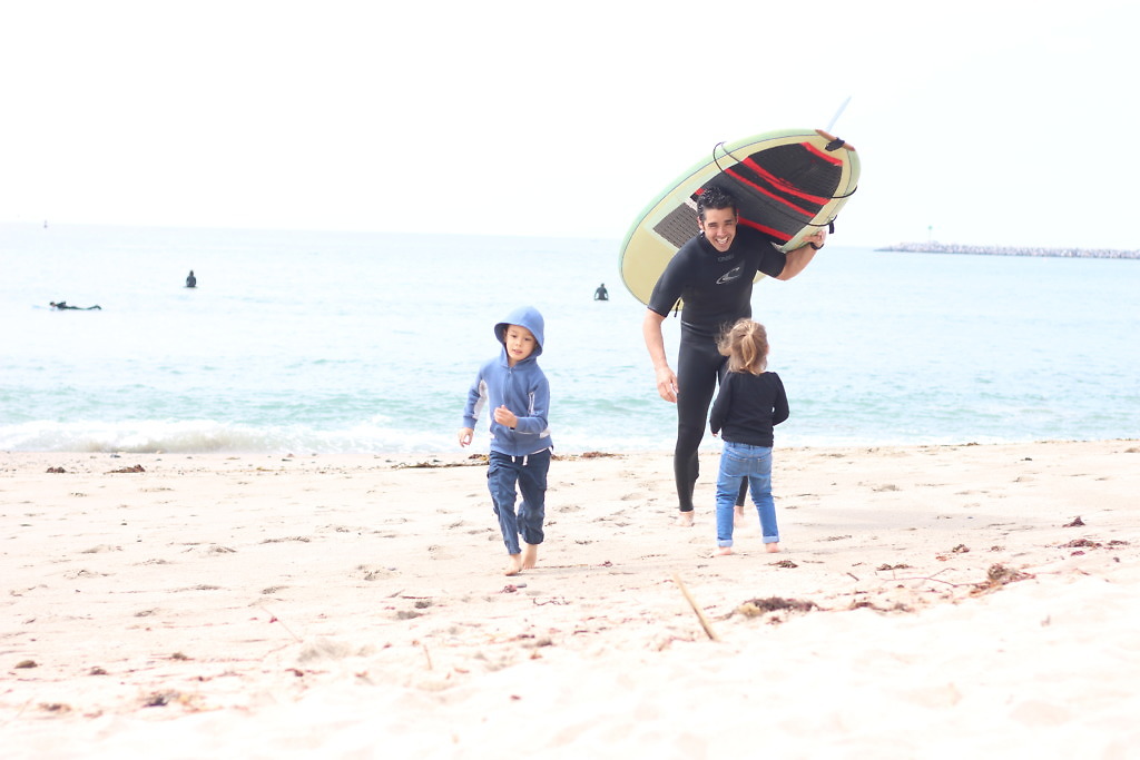 Mochizukis paid off six-figure debt in 33 months. Kyle and the kids at the beach.